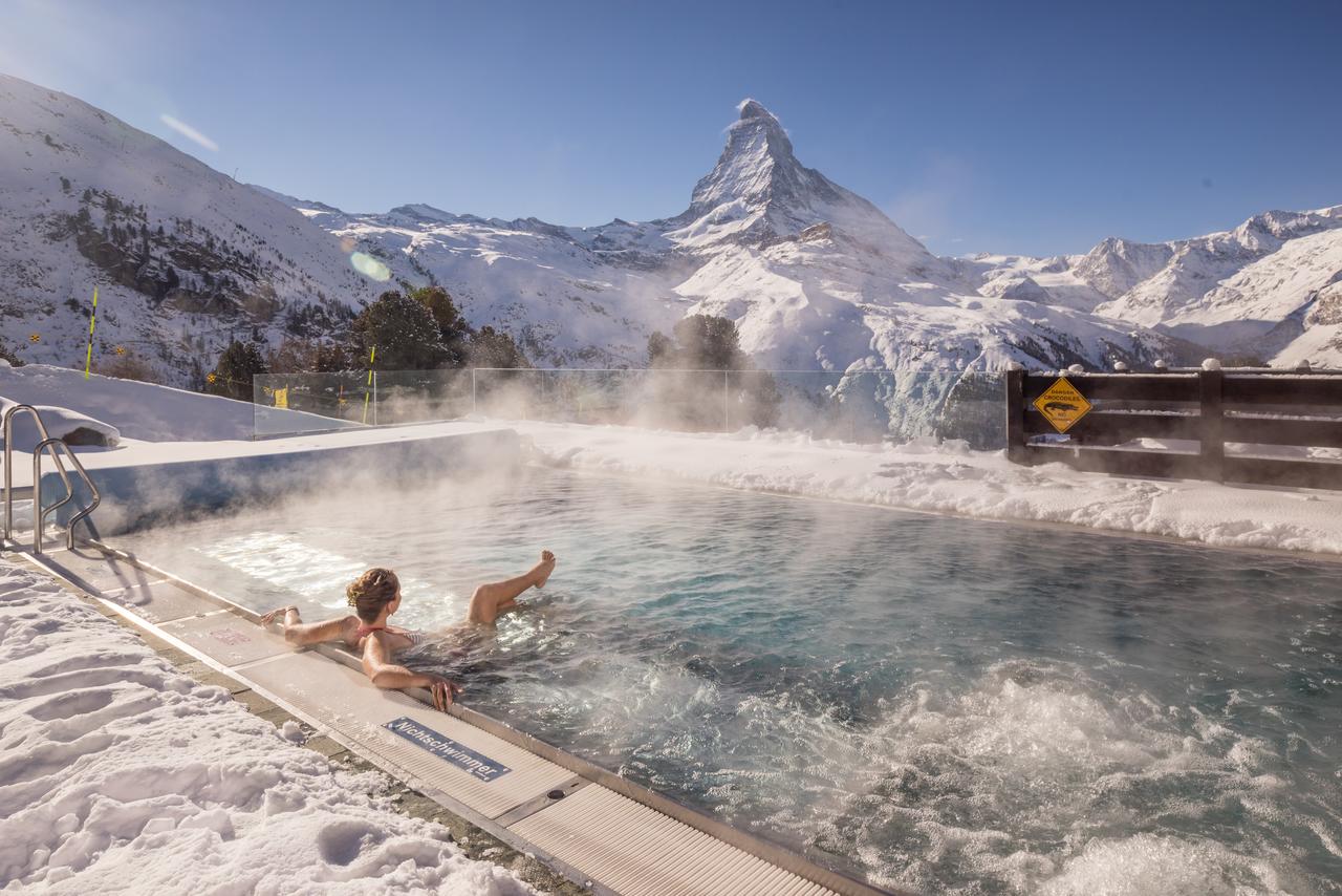The heated outdoor swimming pool of Riffelalp 5 star hotel, with stunning view of Matterhorn.
